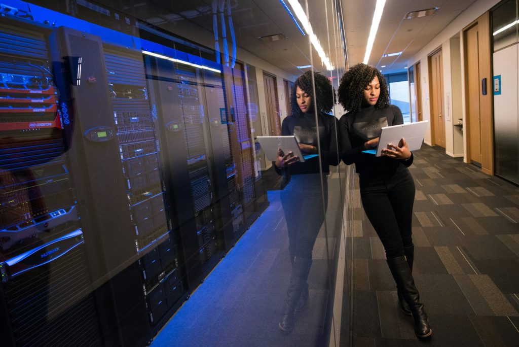 Professional young lady working on her laptop while standing